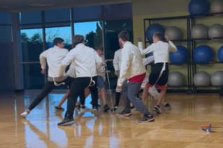 students in class gathered in circle around saber playing a reaction timing game